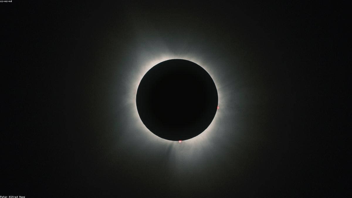 A total solar eclipse against a darkened sky.